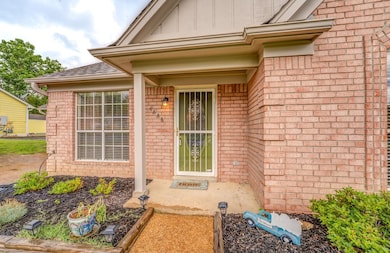 View of exterior entry with brick siding, a shingl