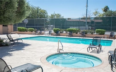 Community pool featuring a patio, fence, and a hot