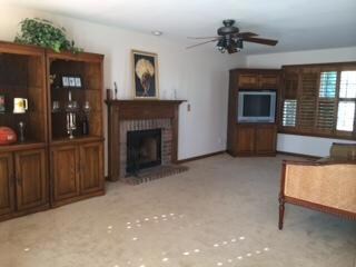 Open floor plan with fireplace in living room, wood plantation shutters on downstairs windows