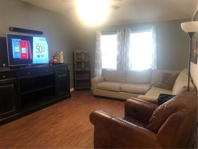 Living room with light wood-style floors and vaul