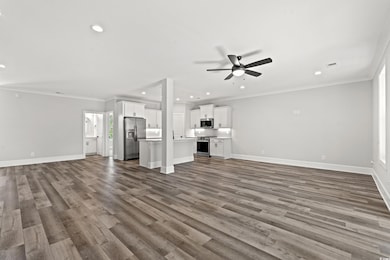 Unfurnished living room with crown molding, hardwo