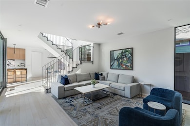 Living area featuring stairway, visible vents, an