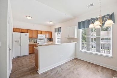 Kitchen with a chandelier, pendant lighting, white