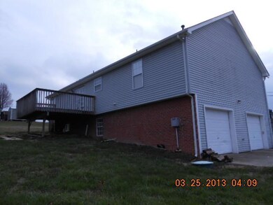 REAR VIEW AND SIDE SHOWING 2 CAR GARAGE IN BASEMENT