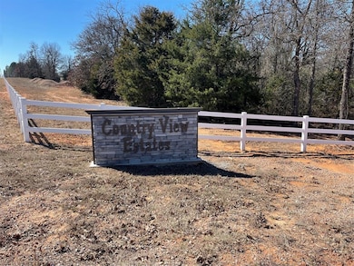 Community sign with a rural view