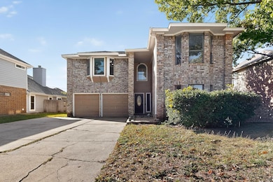 Traditional-style house with concrete driveway, brick siding, and an attached garage