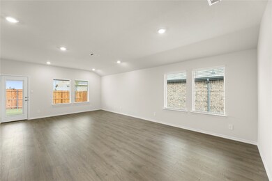 Spare room with healthy amount of natural light, recessed lighting, and wood finished floors