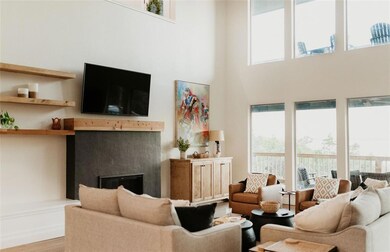 Living area featuring a high ceiling, wood finished floors, and a premium fireplace