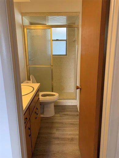 Full bathroom featuring vanity, a shower stall, and dark wood finished floors