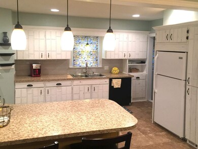 Kitchen has large eating bar and two separate pant
