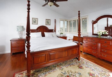 The upstairs master suite is drenched in natural light and is further enhanced by pitched ceilings, a designer lighted ceiling fan, plantation shutters, updated closet and lustrous hardwood floors.