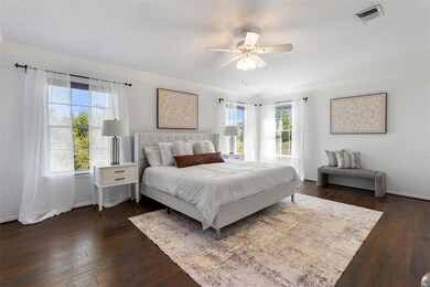 A spacious primary suite complete with a high ceiling, a tremendous amount of natural light, and a ceiling fan.