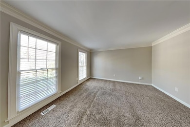 Unfurnished room featuring ornamental molding, bas