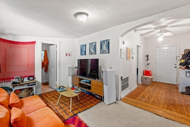 Living room with arched walkways, a ceiling fan, 