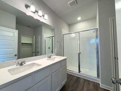 Bathroom featuring visible vents, a stall shower,