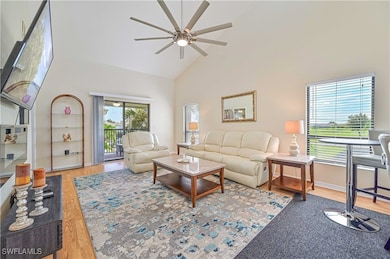 Living room featuring ceiling fan, a high ceiling,