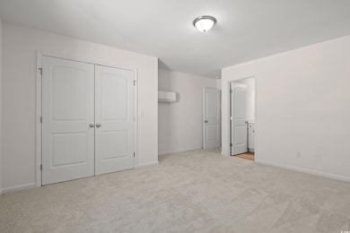 Unfurnished bedroom with light colored carpet, a c