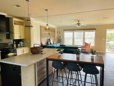 Kitchen with black electric range, crown molding,