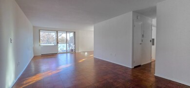 Generously sized living room has newly refinished parquet flooring