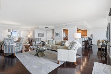 Living area featuring crown molding and dark wood-style flooring