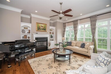 Bright formal living room with built in book cases and gas fireplace