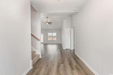 Corridor featuring stairway, wood finished floors, baseboards, and high vaulted ceiling