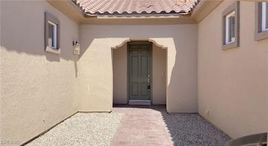 View of exterior entry with stucco siding and a ti