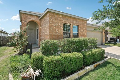 View of front facade with brick siding, a garage,