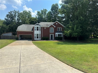 View of front of home featuring driveway, brick siding, and a garage