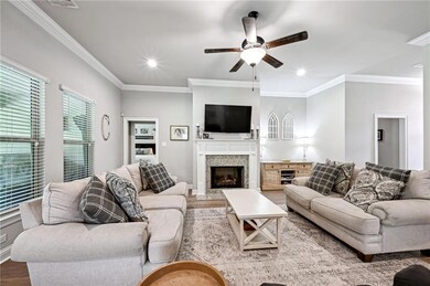 Living area with wood look tile, crown moulding, a