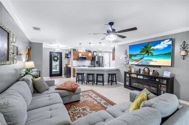 Living room featuring ornamental molding, light tile patterned floors, and ceiling fan