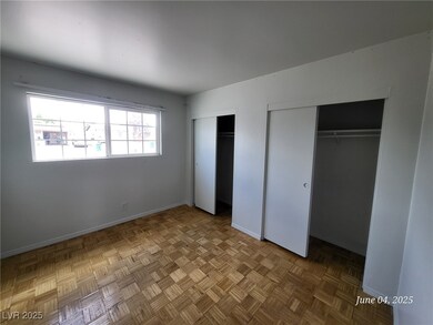 Unfurnished bedroom with two closets and baseboard