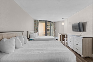 Bedroom featuring a textured wall, dark wood finished floors, a textured ceiling, and access to exterior