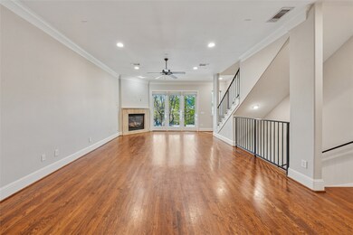Unfurnished living room with ornamental molding, a fireplace, wood finished floors, recessed lighting, and french doors