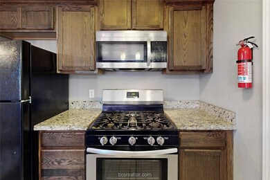 Kitchen featuring appliances with stainless steel finishes and light stone counters