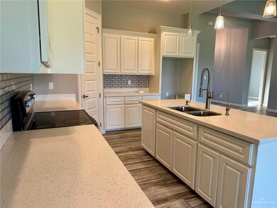 Kitchen featuring electric range oven, white cabinets, tasteful backsplash, and hanging light fixtures