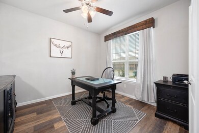 Nestled away quietly in the front of the home is the handsome home office! Featuring high ceilings, rich stained ceiling fan, custom paint, wood like flooring and large windows with privacy blinds.