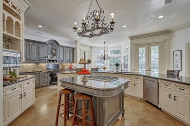 Massive Chef's kitchen, granite counters, expansive breakfast bar, Island with additional seating & stainless steel Wolf 5-burner gas cooktop. Stainless steel Whirlpool trash compactor, dishwasher & Dacor microwave. Pantry with automated lighting.