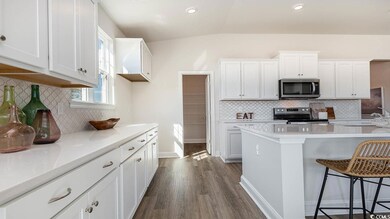 Kitchen featuring white cabinetry, stainless steel