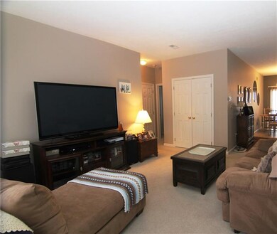 Spacious living room with lots of natural light filtering in through the windows. Window treatments are included.