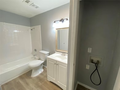 Bathroom featuring vanity, light wood-style flooring, and bathing tub / shower combination