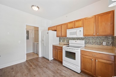 Kitchen with backsplash, light hardwood / wood-sty