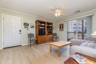 Living room featuring ceiling fan, crown molding, 
