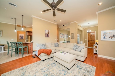 Living area with crown molding, wood finished floors, ceiling fan, a chandelier, and recessed lighting