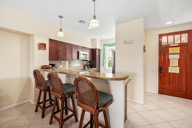 Kitchen with granite countertops, breakfast bar seating