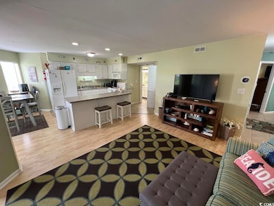Living area with recessed lighting, light wood-style floors, and baseboards