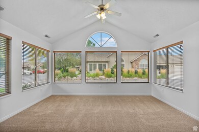 Unfurnished sunroom featuring vaulted ceiling and carpet