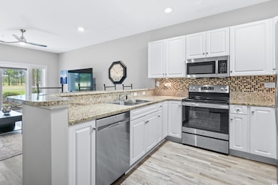 Kitchen featuring kitchen peninsula, ceiling fan, 