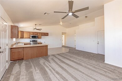 Kitchen with vaulted ceiling, light carpet, applia