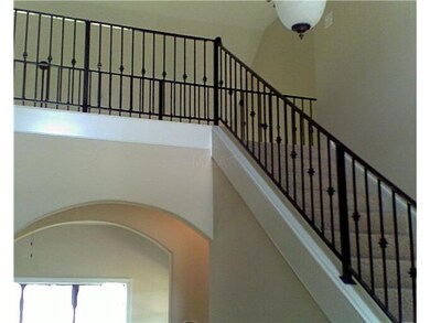 FOYER WITH ARCHES AND WROUGHT IRON ON STAIRS & BAL